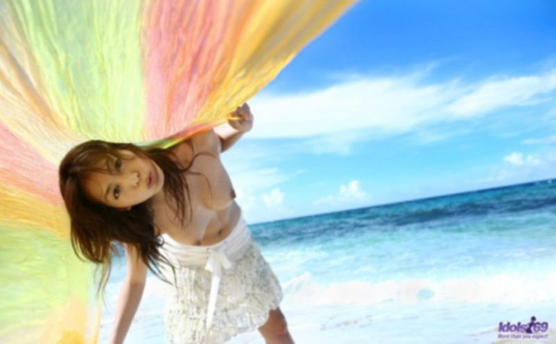 Молодая японская девушка позирует на пляже